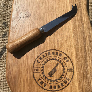 
                  
                    Cheese knife with prongs sitting on a cheese board
                  
                